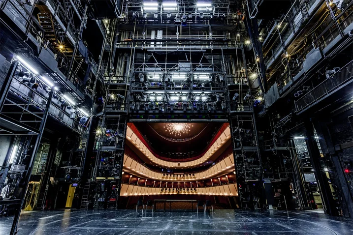 Das Bild zeigt die beeindruckende Bühne des Thalia Theaters mit leeren Zuschauerrängen und komplexer Bühnentechnik.