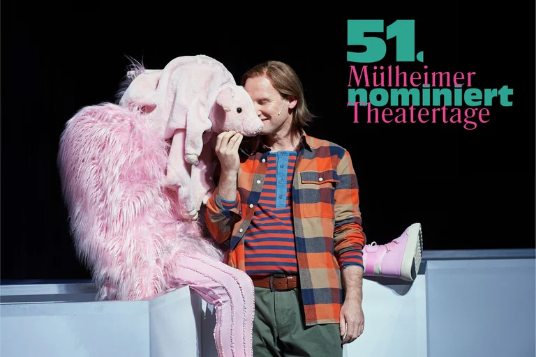 Ein Mann in einem bunten Hemd steht neben einer Person im rosa Kostüm. Text: "51. Mülheimer Theatertage".