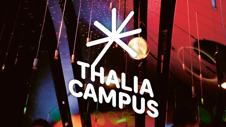 Eine bunte Beleuchtung mit einem leuchtenden Logo, das "Thalia Campus" in weißen Buchstaben zeigt. Kunstvolle und moderne Atmosphäre.